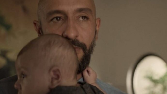 o personagem de Irandhir Santos, com um olhar ameaçador, segura um bebê
